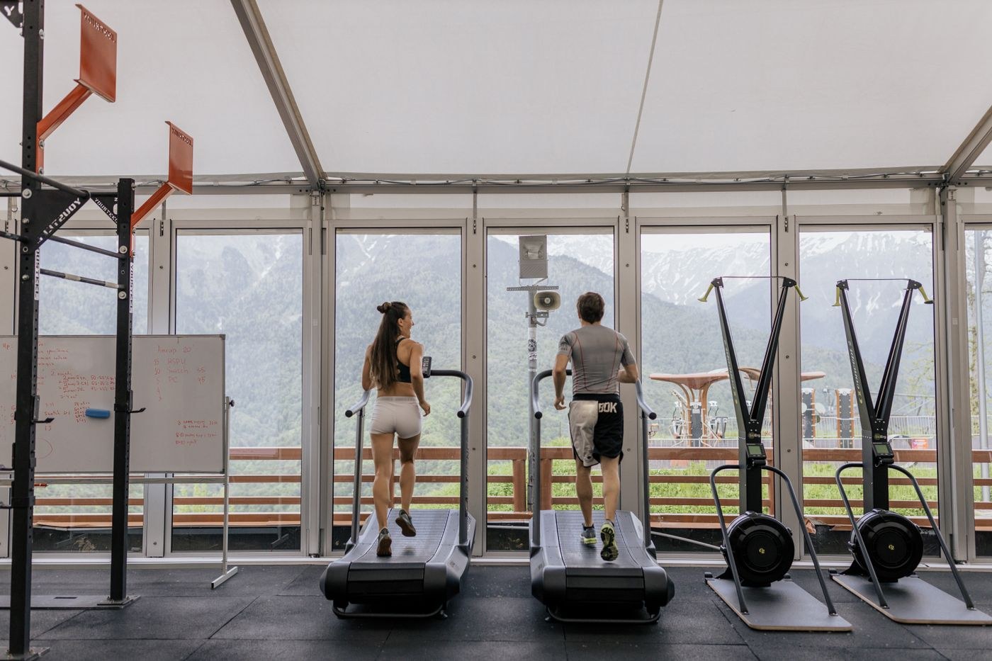 Two people using adjacent treadmills at their own pace.
