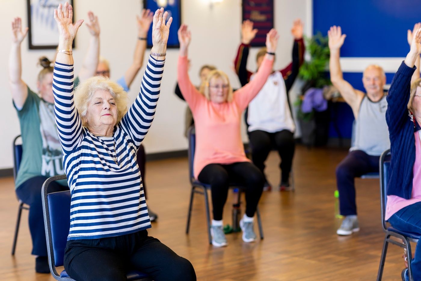 Adults taking part in a seated group movement session.