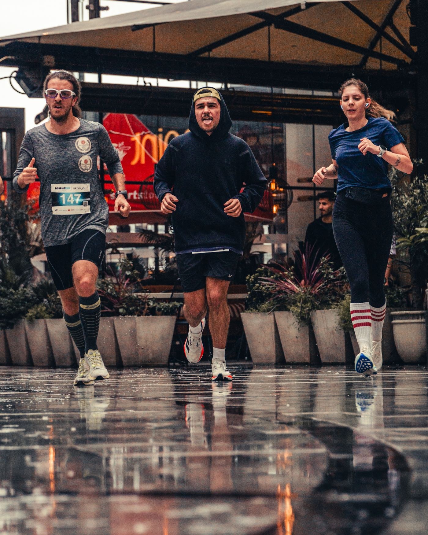 Runners moving across wet paving after rain.