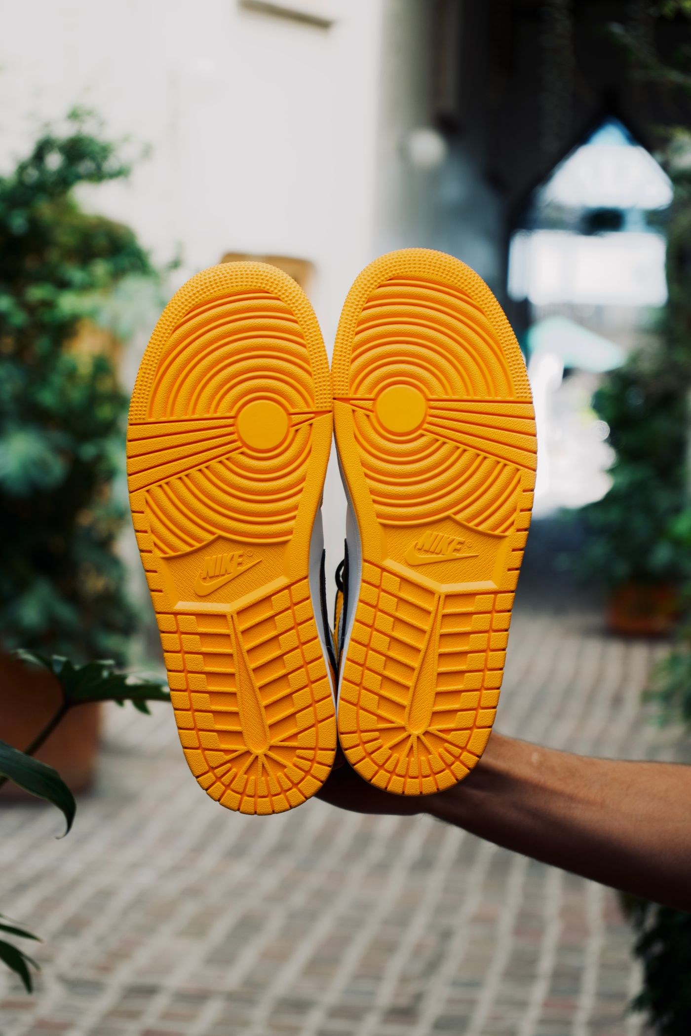 Close view of patterned rubber soles on a pair of sports shoes.