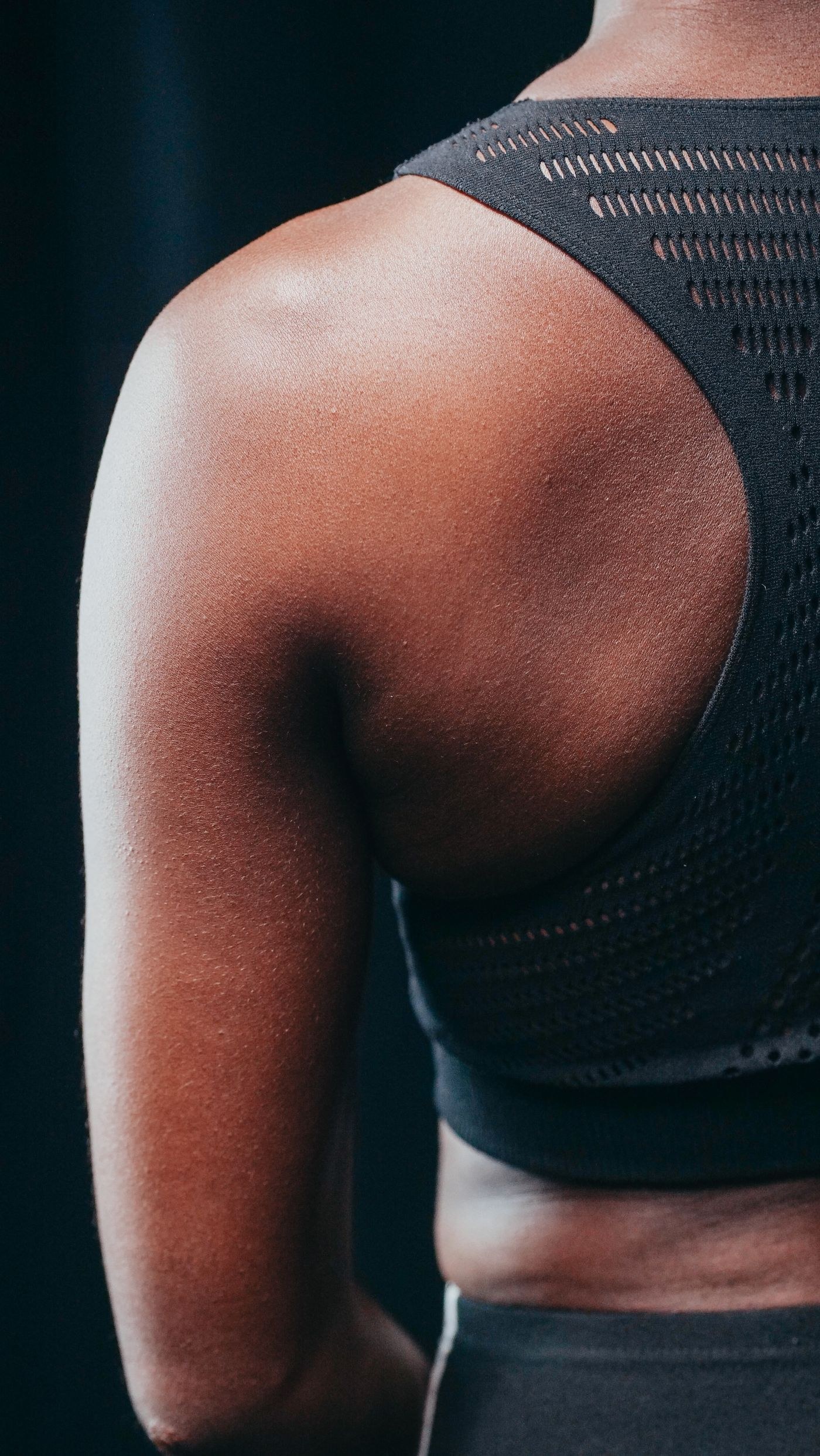 The shoulder strap and back of a black sports bra.