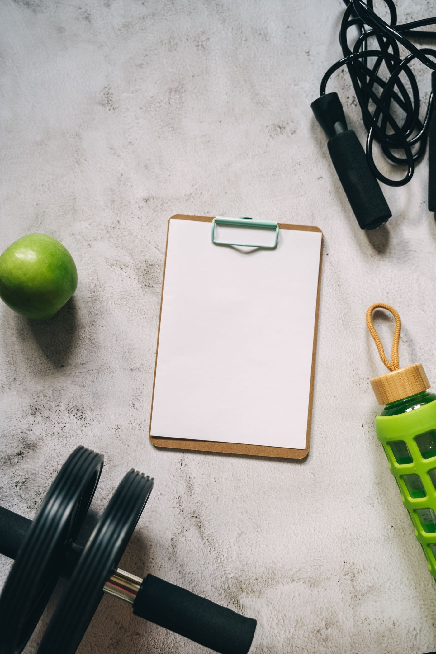 An empty clipboard surrounded by exercise equipment for recording a session.