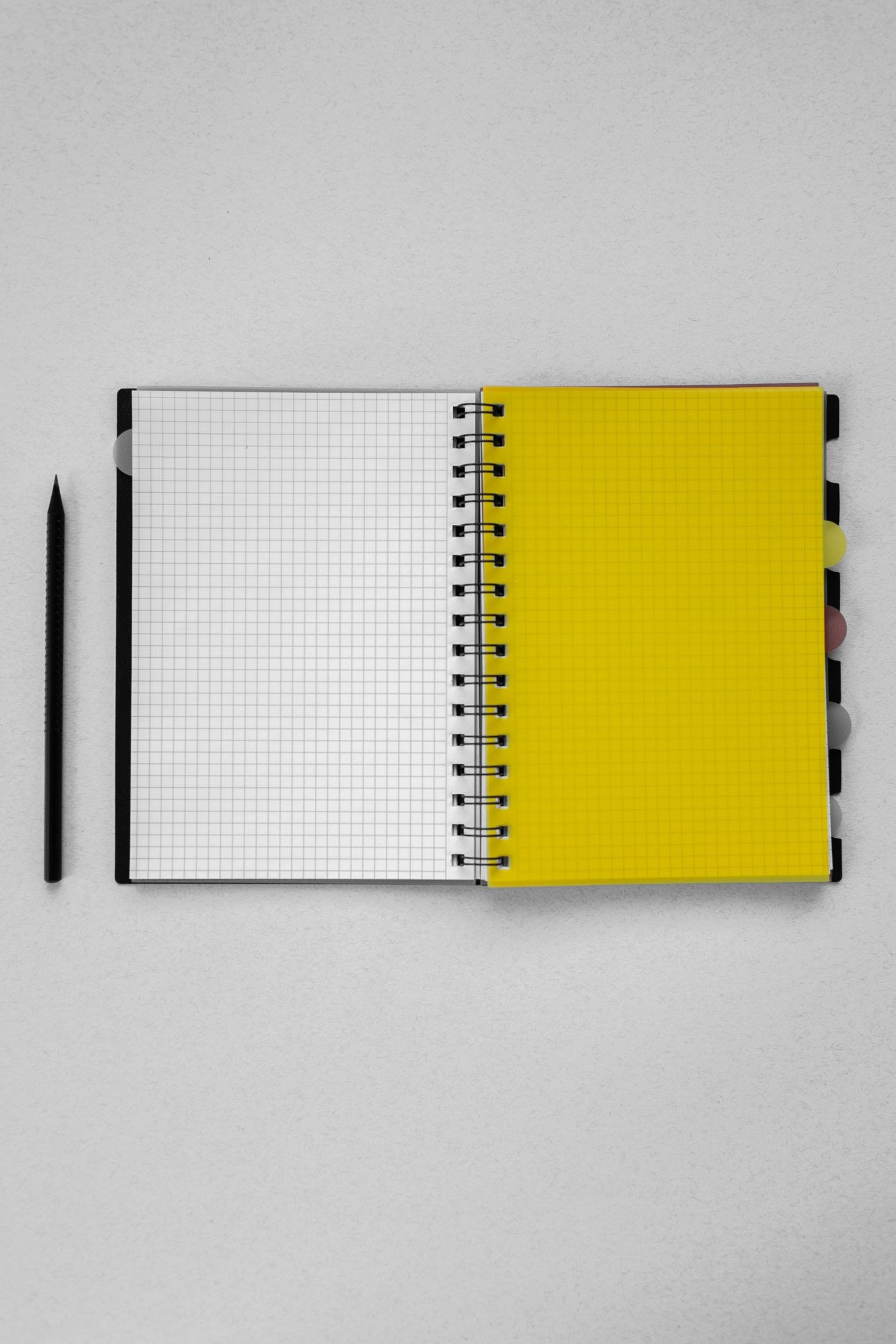 An open grid notebook and pencil for reviewing what to repeat or change.