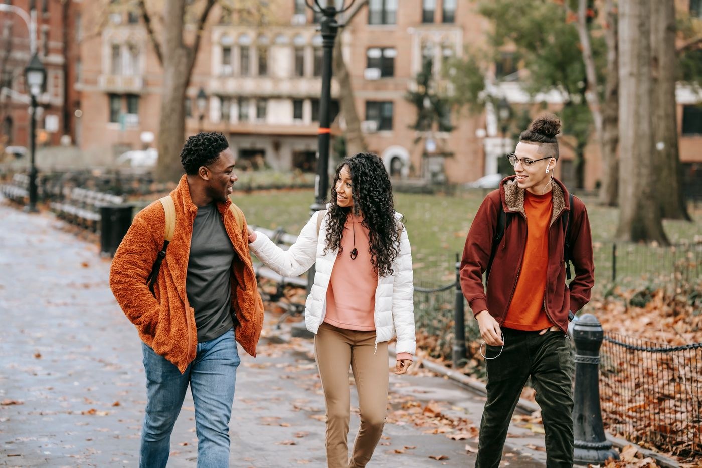Friends walking along a familiar park path in autumn.